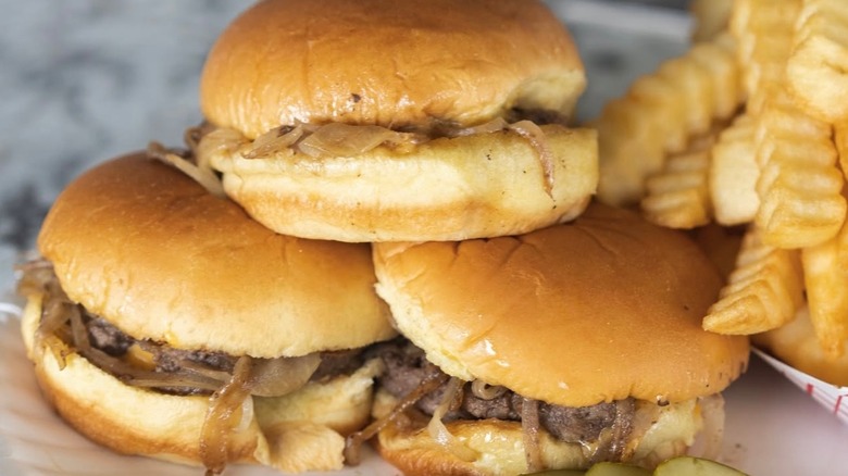 Burgers with onions and side of crinkle cut fries from White Manna