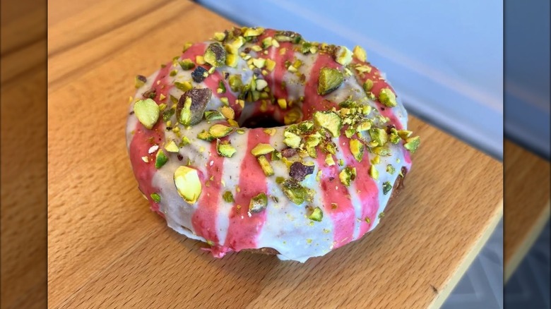 White and pink iced donut with pistachio
