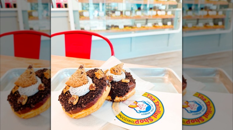 Two chocolate and cookie donuts on tray
