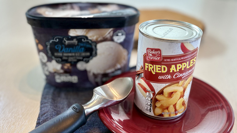 A can of Aldi fried apples with cinnamon with a tub of ice cream and a scooper