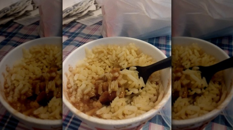 A side of Popeyes' Red Beans and Rice with a spoon sticking out of it