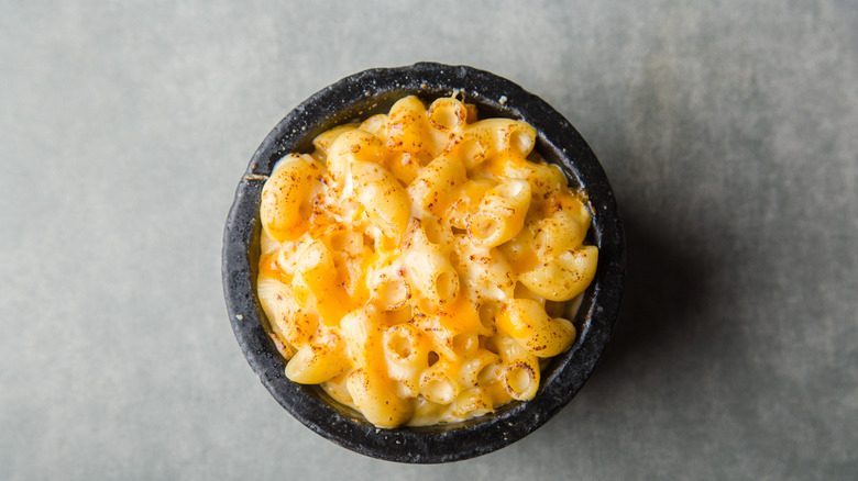 A small bowl of mac and cheese with seasoning on top.