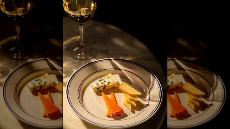 Three types of sliced cheeses on white plate