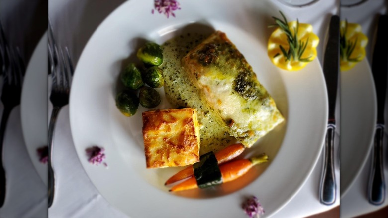 French cuisine, meat, Brussels sprouts, carrots, on white plate
