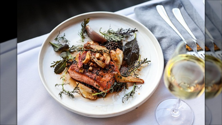Salmon with vegetables on white plate