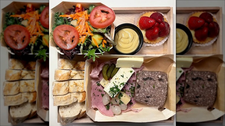 Wood box of salad, meat, and cheese with bread and pastry