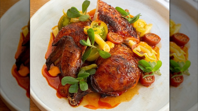 Chicken pieces topped with sliced small tomatoes