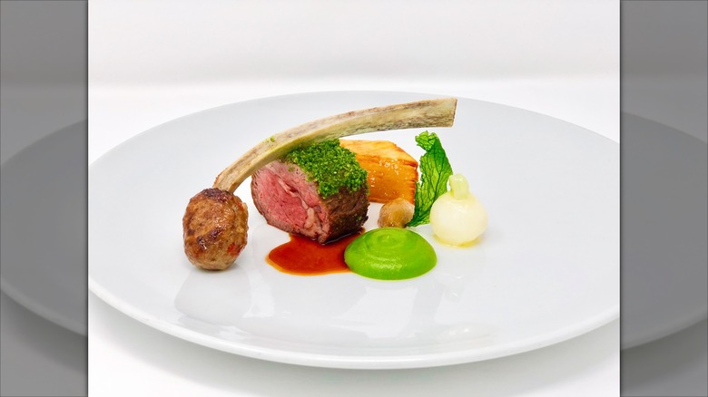 Slice of beef and meatball next to red and green sauce