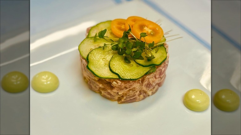 Tuna tartare with sliced pickles and tomato