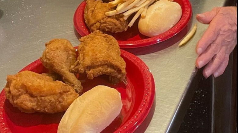 Broasterant fried chicken on red plate with dinner roll