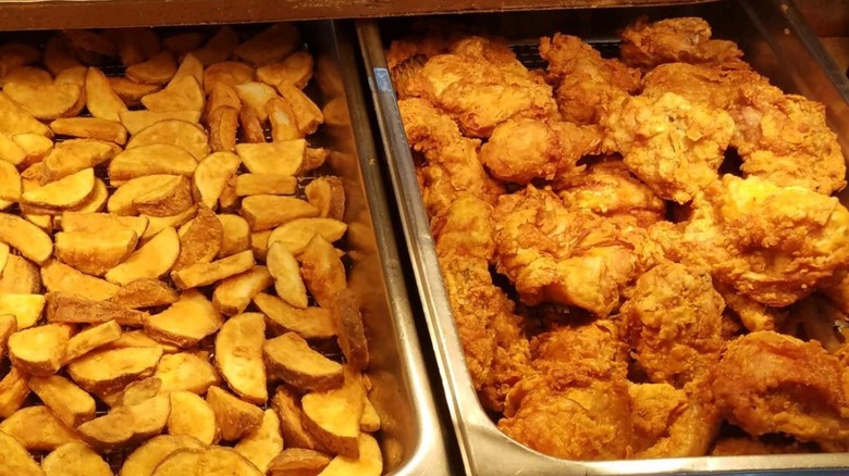Jan's Fried Chicken fried chicken tray beside a tray of potato skins