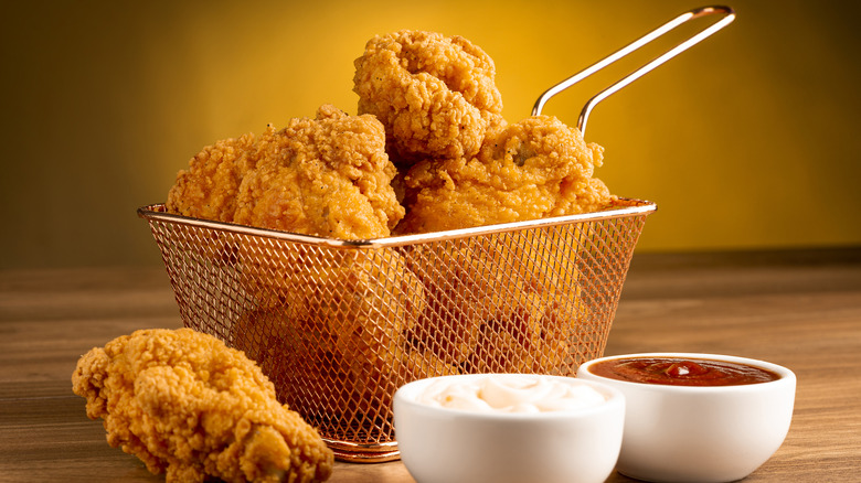 Fried chicken in a basket with ketchup and mayonnaise on the side