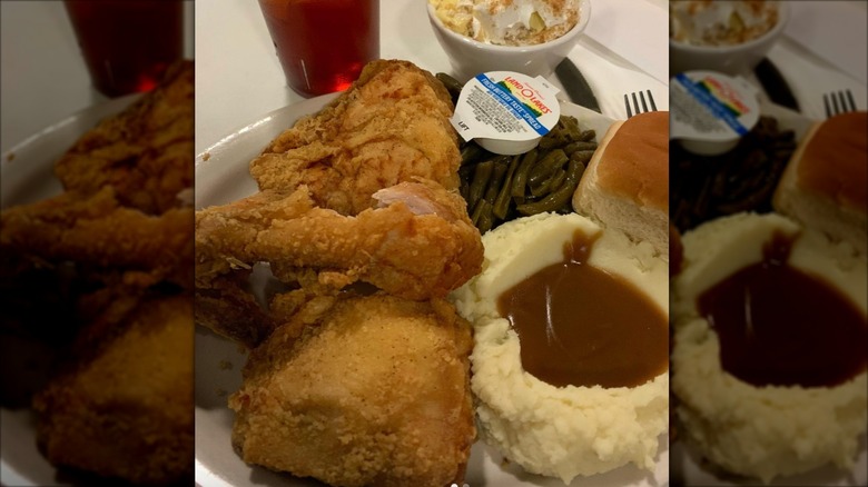 Virlie's Grill fried chicken with sides of biscuit mashed potatoes green beans and mini packet of butter