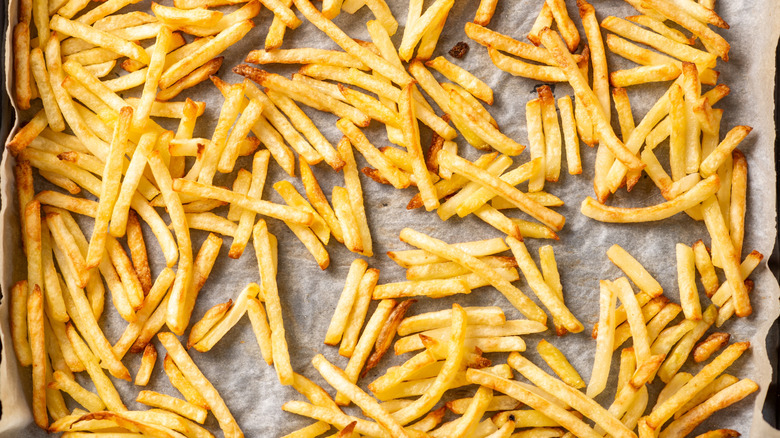 Close-up of cooked frozen french fries on baking sheet
