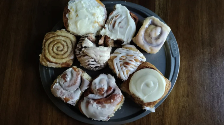 Nine different cinnamon rolls on a plate on a table.