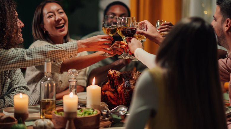 Thanksgiving gathering with turkey and candles on the table