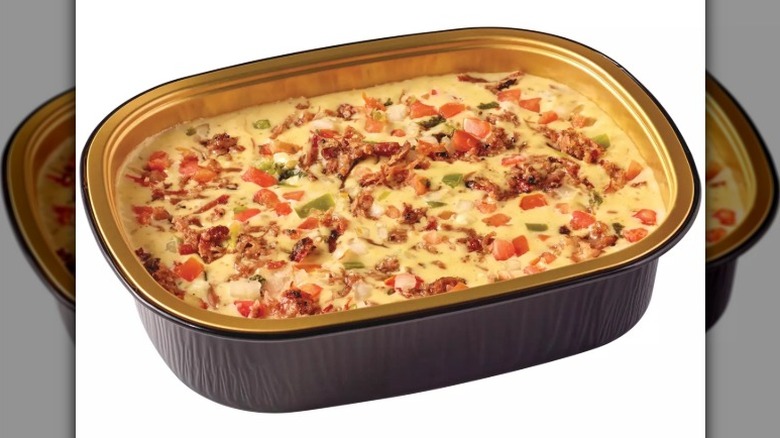 open container of brisket queso dip with pico de gallo