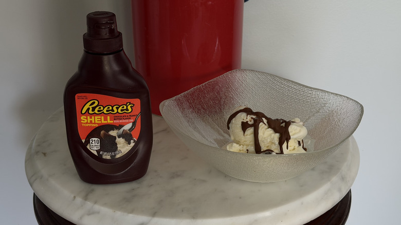 Hershey's Reese's Shell product next to bowl of ice cream with syrup on it.