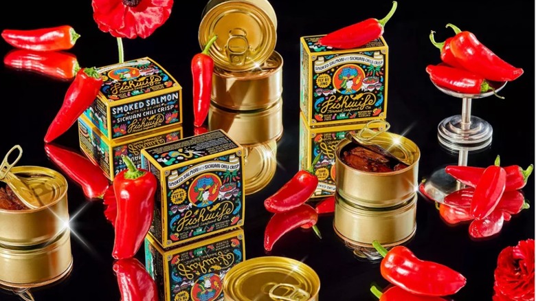 Cans and boxes of Fishwife Smoked Salmon with Sichuan Chili Crisp and fresh red chile peppers
