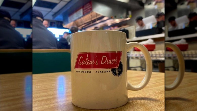 Salem's Diner Interior with a closeup of a coffee mug with the logo on it and interior blurred in background