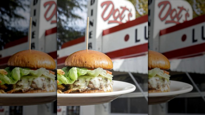 Burger in front of white and red diner exterior