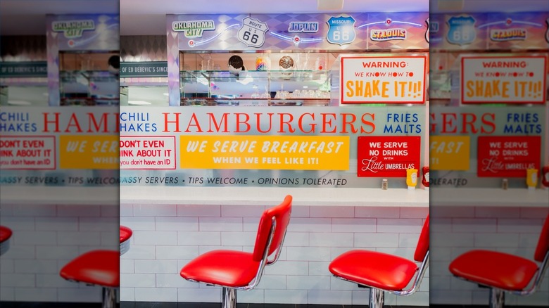 Read chairs in front of sign and kitchen area at diner
