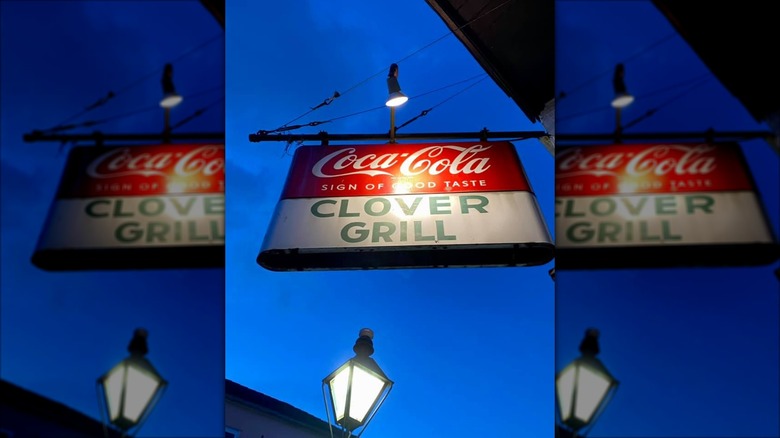 Exterior sign at night on Clover Grill