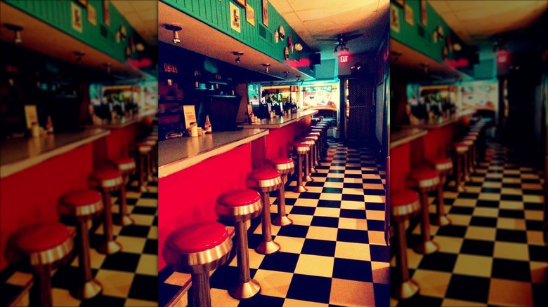 Lost in the 50's Diner interior with checkerboard floor, counter and old school bar stools