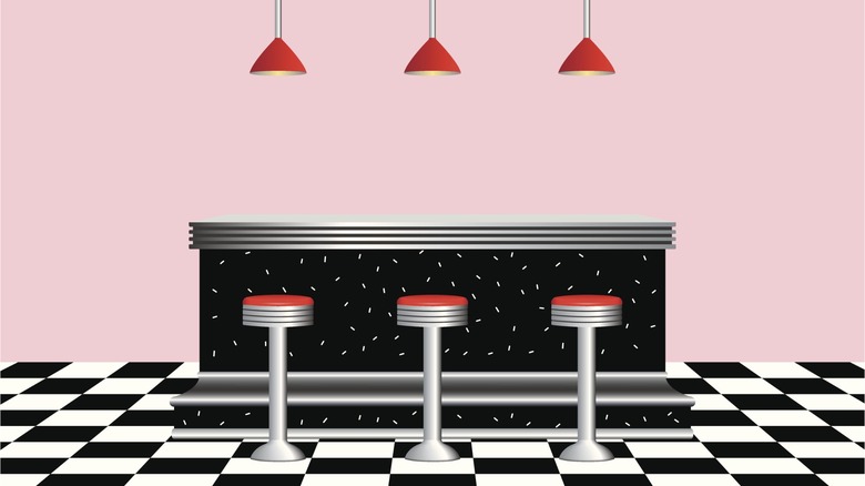 Cute cartoon diner picture with pink walls, old school counter, and red bar stools with red hanging lamps, very retro