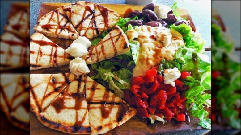 Sliced pita triangles, hummus, and salad from Aliki's Greek Taverna