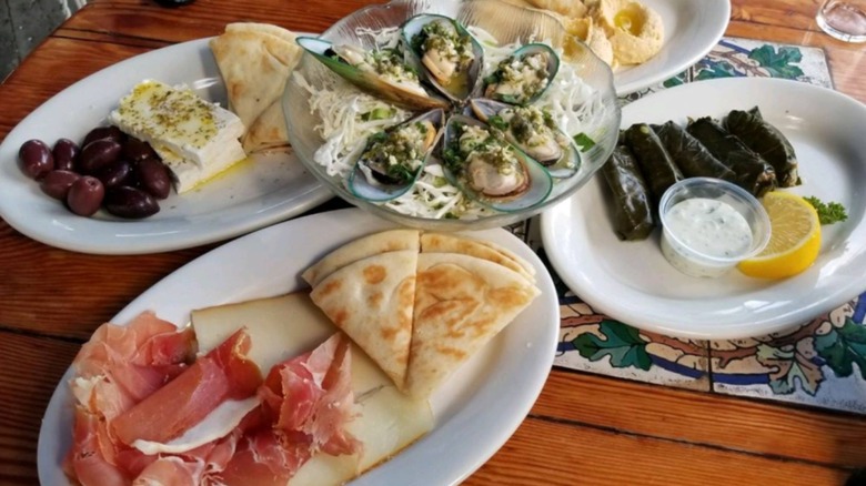 Assorted Greek dishes. like pita bread, dolmades, oysters, feta with olive oil, and olives, at Olive Tree Cafe
