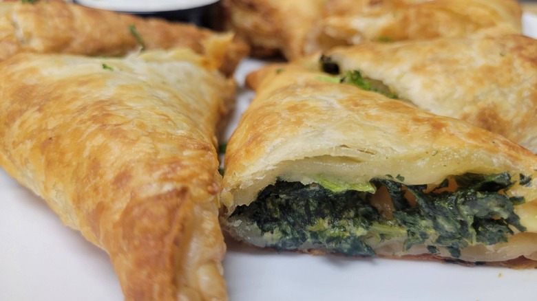 Sliced spanakopita from Kosta's Taverna on a white plate
