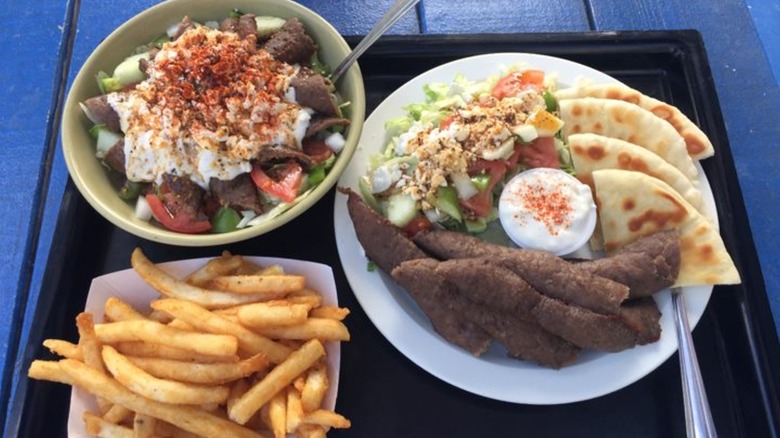 Greek food spread with meat, salad, pita, and french fries from The Greek Pastry Shop