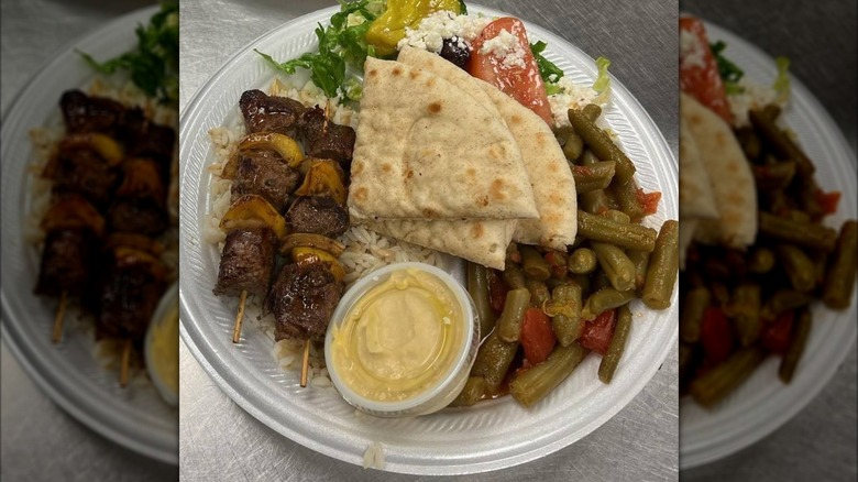Plate of Greek food with kabobs, pita, Greek salad, green beans ,and rice from Best of Crete Deli