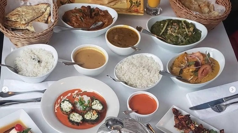 A big spread of delicious Indian food including rice, naan, greens, and various curry dishes at Curry Leaves in Tampa