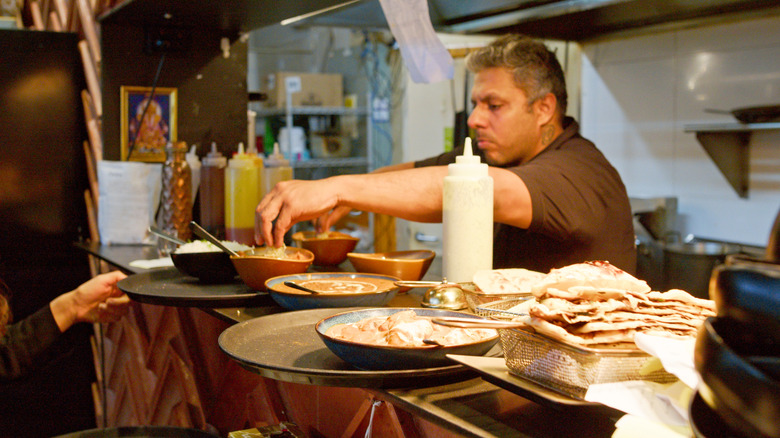 A chef adds the finishing touches to a curry