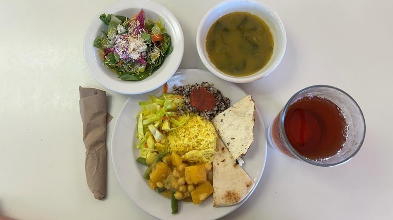 A selection of plates from Good Karma Cafe including a curry with rice and naan, a soup, and a salad