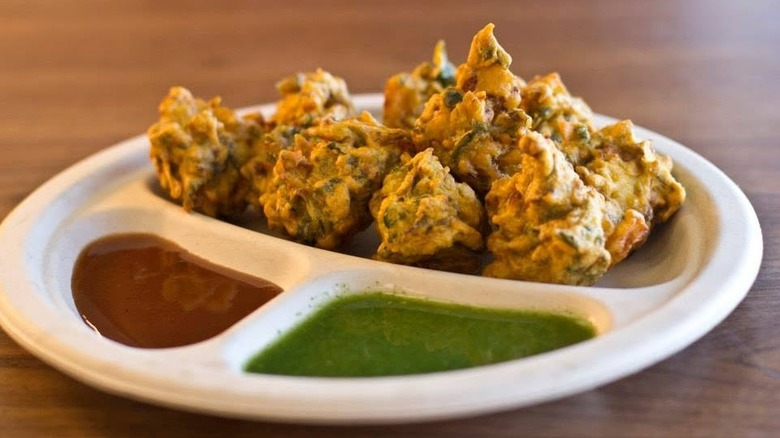Pakoras with two dipping sauces on a white plate from Rani's World Foods - Las Vegas