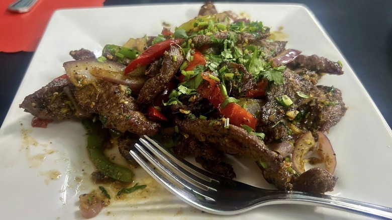 A plate of spicy beef on a white plate from Curry and Nest