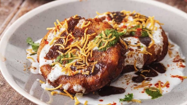 A delicious dish covered in crispy onions and a white sauce in a white bowl from Curry Corner