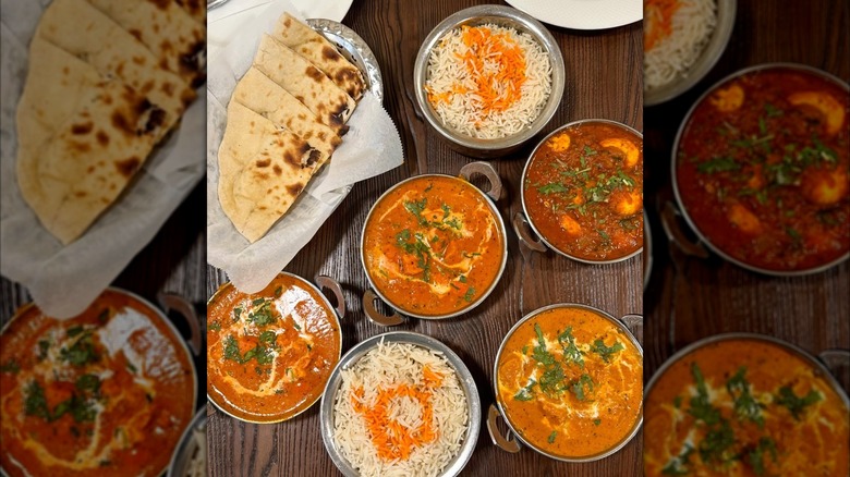 A delicious spread of curry, rice, and naan in metal bowls from Kohinoor Dhaba