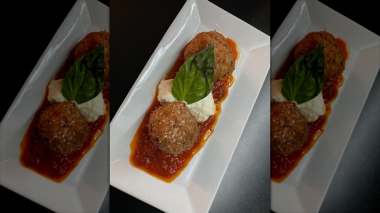 Two meatballs with burrata in between