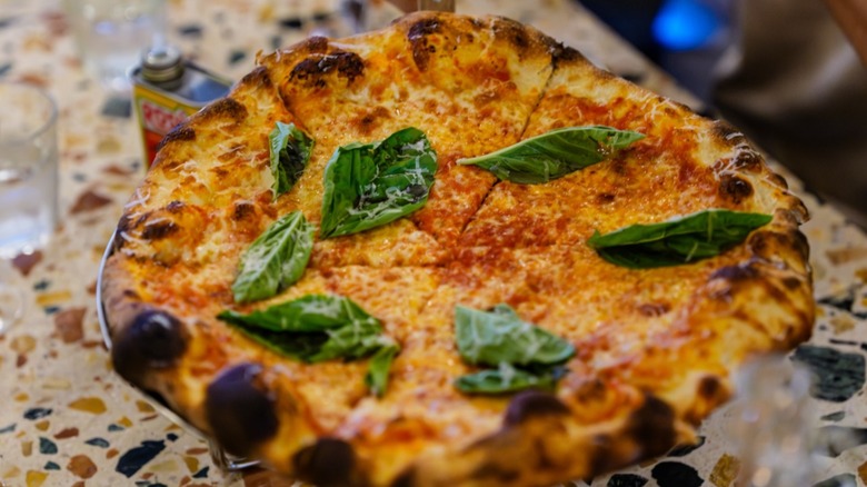 Whole pizza with fresh basil from Marc's Artisanal Pizzeria