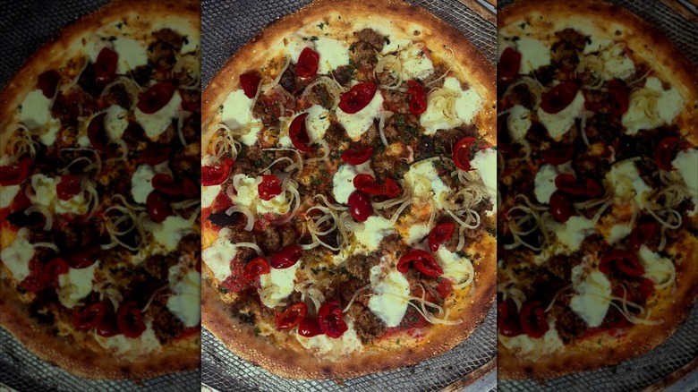 Fennel sausage, cherry peppers, house red, white onion, sesame seeded crust pizza special from Little G Cafe