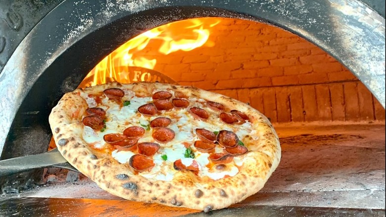 Neopolitan pizza being pulled from the oven at Righteous Slice