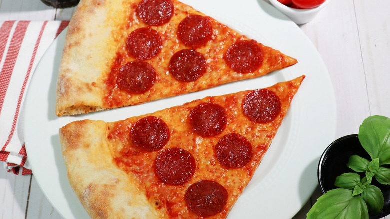 Two slices of pepperoni pizza on a white plate from TinyBrickOven