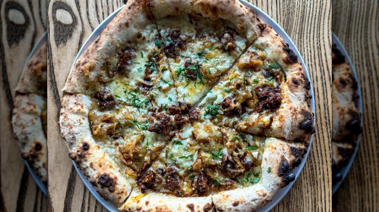 Slow-braised beef short rib, melty gruyère, caramelized onions, red wine reduction pizza slice from Jinny's Pizzeria