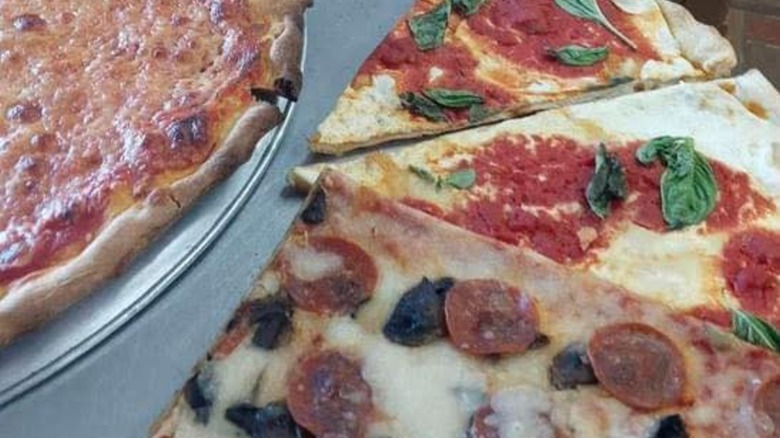 Various slices of pizza, including pepperoni, fresh basil, and cheese, from Il Bambini Pizzeria