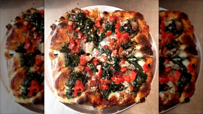 Whole pizza with fresh diced tomatoes, cheese, and greens from Square Pie
