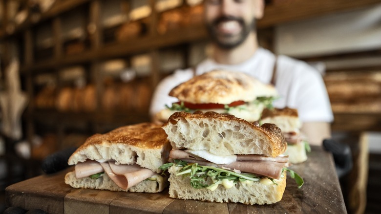 Man working in sandwich shop serving fresh sandwiches